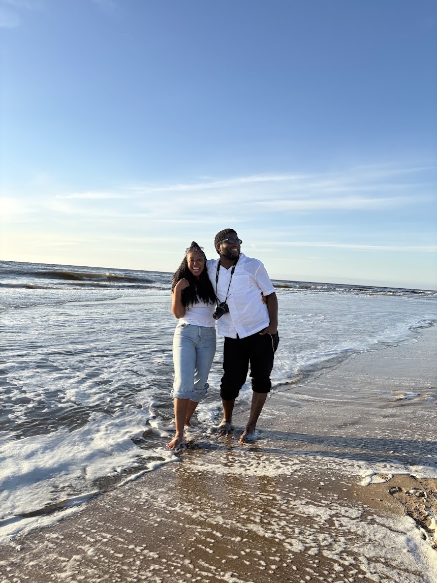 Chisom and Enoch smiling together by the sea